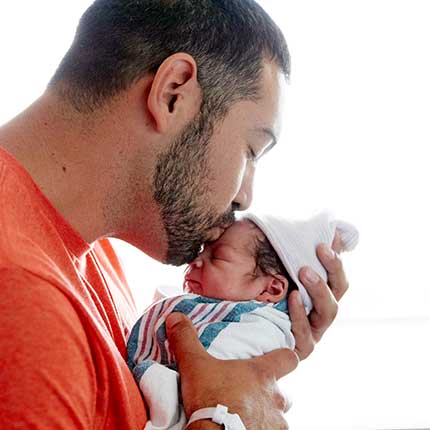 Dad kissing newborn